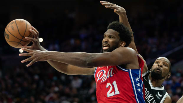 Oct 22, 2021; Philadelphia, Pennsylvania, USA; Philadelphia 76ers center Joel Embiid (21) passes the ball in front of Brooklyn Nets forward Kevin Durant (7) during the fourth quarter at Wells Fargo Center. Mandatory Credit: Bill Streicher-USA TODAY Sports